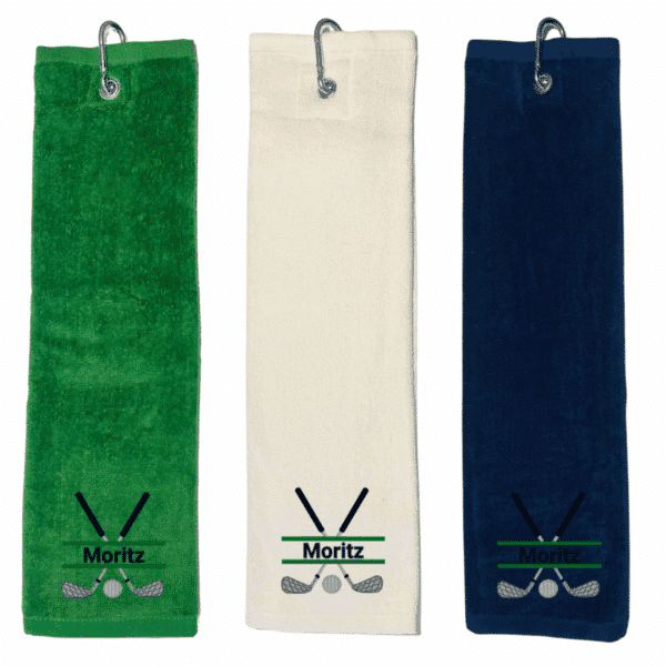 Golfhandtuch mit Golfschläger und Name in den Farben Grün, Weiß und Blau, jeweils mit einem gestickten Golfmotiv und dem Namen "Moritz". Jedes Tuch hat einen Haken zum Aufhängen.