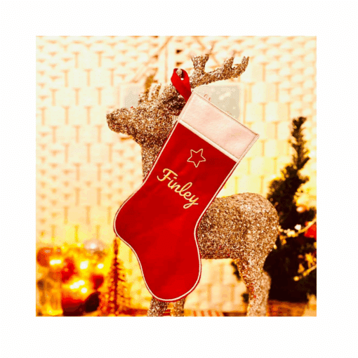 Ein roter personalisierter Weihnachtsstrumpf hängt an einem glitzernden Rentier