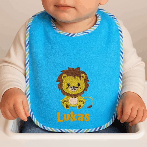 Baby trägt Wörner Lätzchen mit Löwen-Motiv und Name Lukas