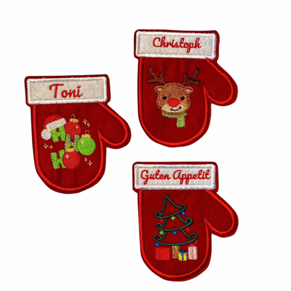 Drei personalisierte Besteckhalter für Weihnachten aus Filz in Handschuhform mit Stickmotiven wie Rentier, Tannenbaum und Ho Ho Ho sowie Namen und Sprüchen.