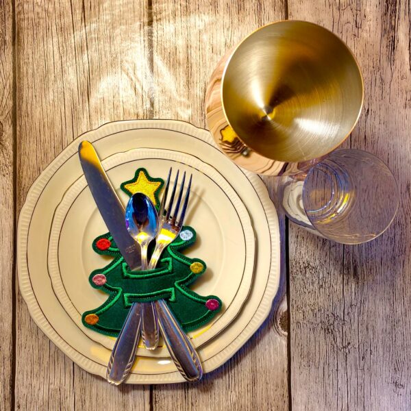 Festlich gedeckter Tisch mit einem Besteckhalter Tannenbaum für Weihnachten aus grünem Filz, dekoriert mit Kugeln und Stern.