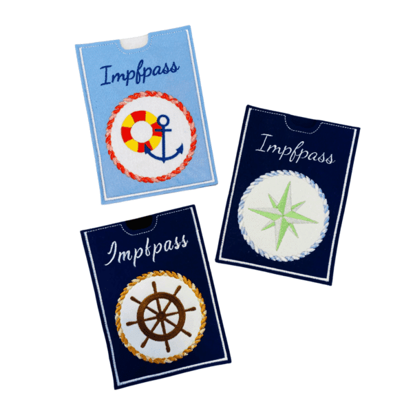 Drei maritime Impfausweishüllen aus Filz mit Stickmotiven wie Anker, Kompass und Steuerrad
