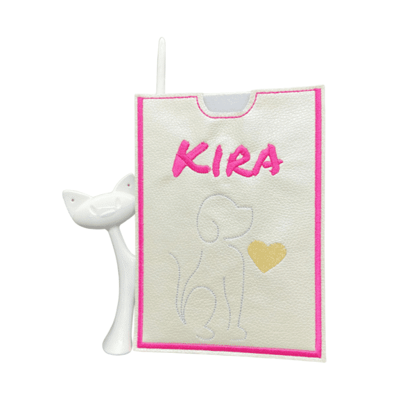Weiße Impfausweishülle aus Kunstleder für Hunde mit dem Namen Kira und einem goldenen Herz.