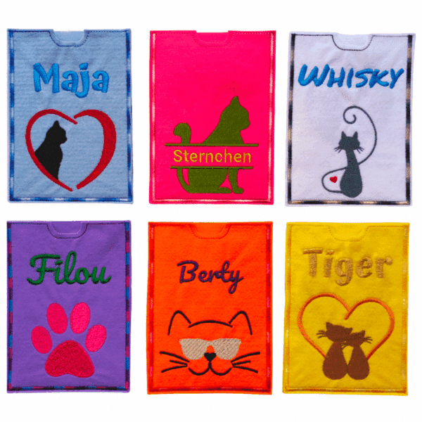 Sechs bunte Impfausweishüllen aus Filz mit Katzenmotiven und Namen, in leuchtenden Farben wie Pink, Lila und Gelb.