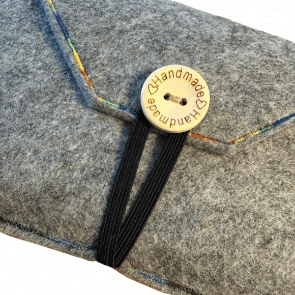 Nahaufnahme der geschlossenen Handyhülle mit Holzknopf "Handmade" und Gummiband