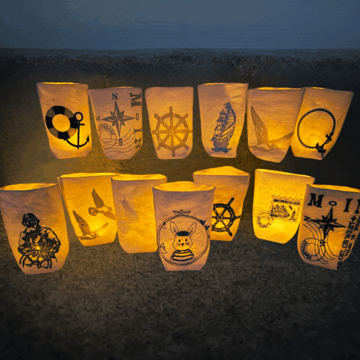 Verschiedene Lichtbeutel mit maritimen Motiven wie Anker, Steuerrad und Kompass im warmen Licht