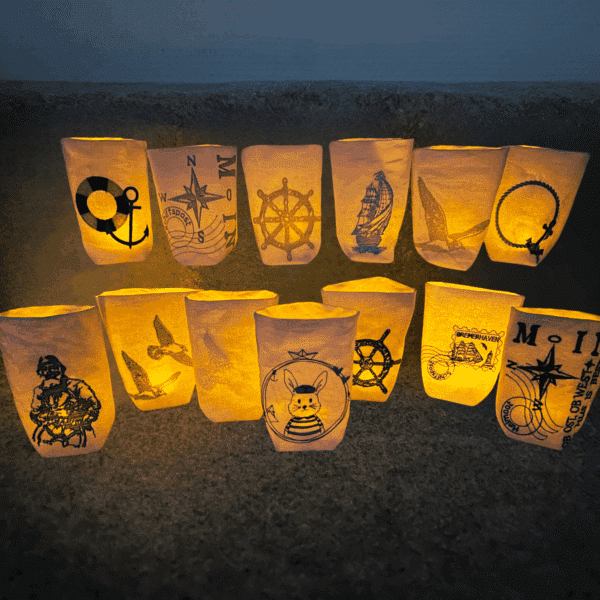 Verschiedene Lichtbeutel mit maritimen Motiven wie Anker, Steuerrad und Kompass im warmen Licht