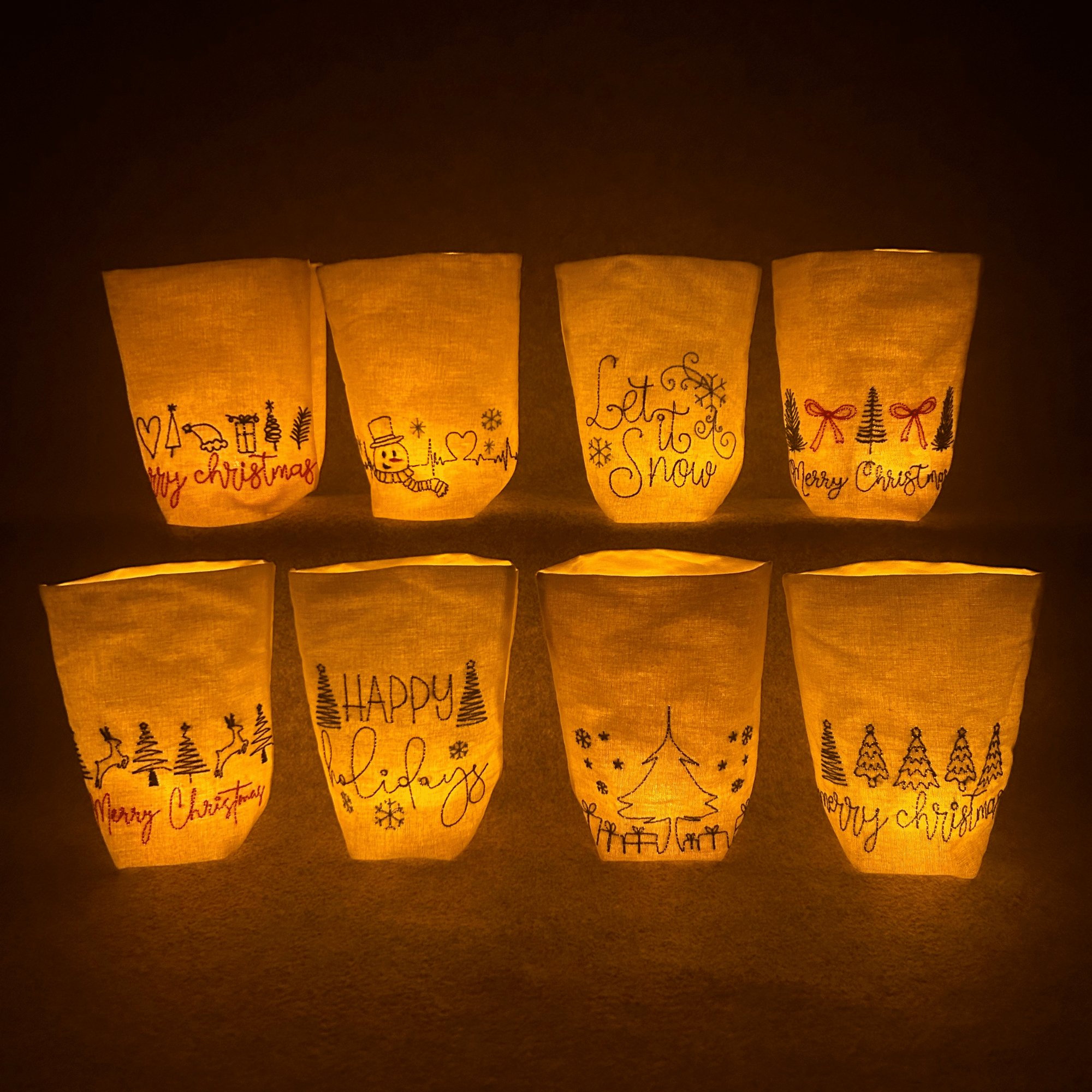Lichtbeutel mit weihnachtlichen Motiven in festlicher Übersicht – acht beleuchtete Stofflichter mit Weihnachtsstickerei