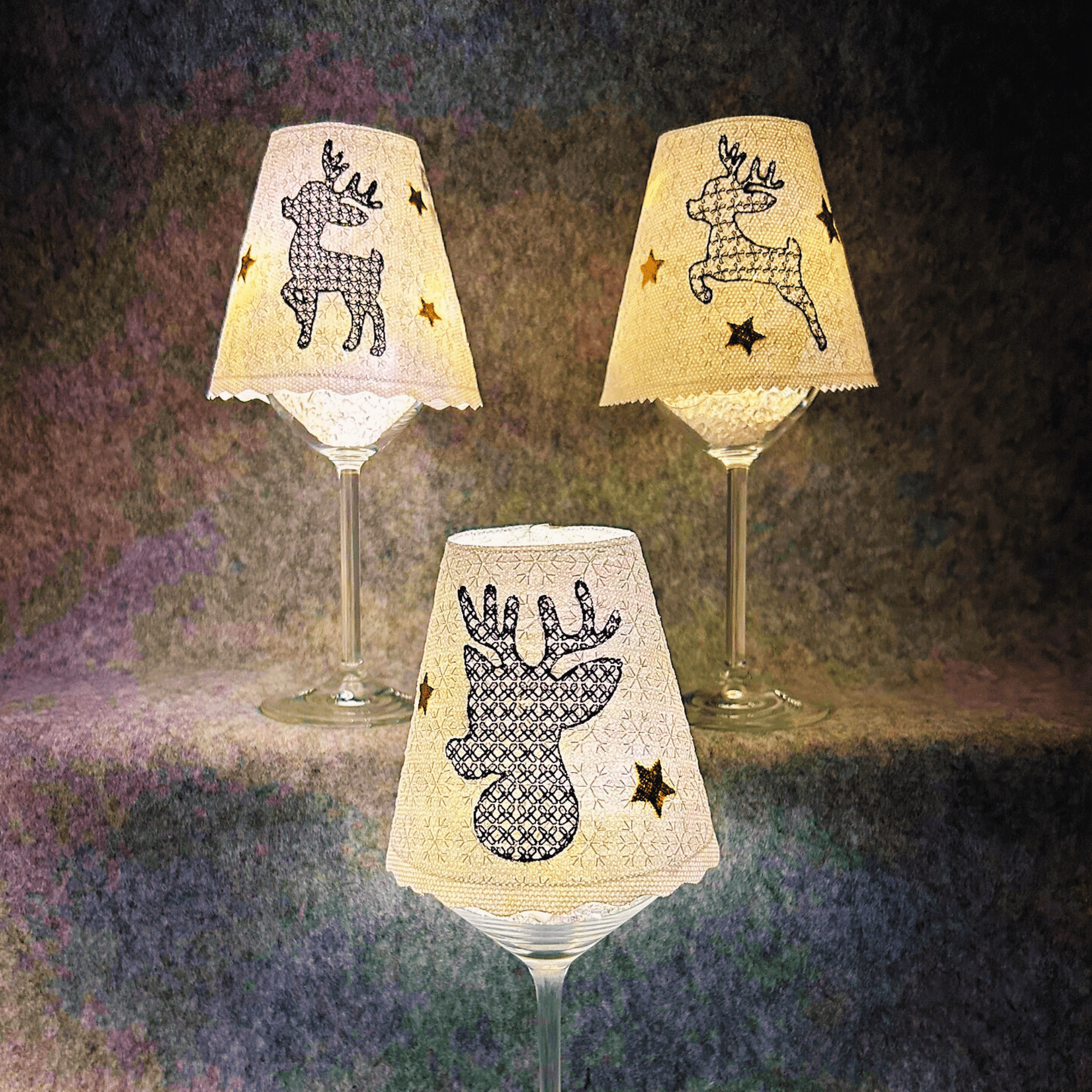 Lampenschirm Weinglas mit Weihnachtsmotiven – Rentier-Designs mit goldenen Sternen, beleuchtet für festliche Stimmung.