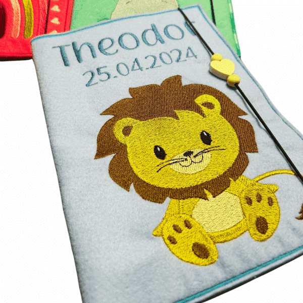 U-Heft-Hülle aus Filz in Helllblau mit Löwenmotiv, personalisiert mit Name Theodor und Geburtsdatum
