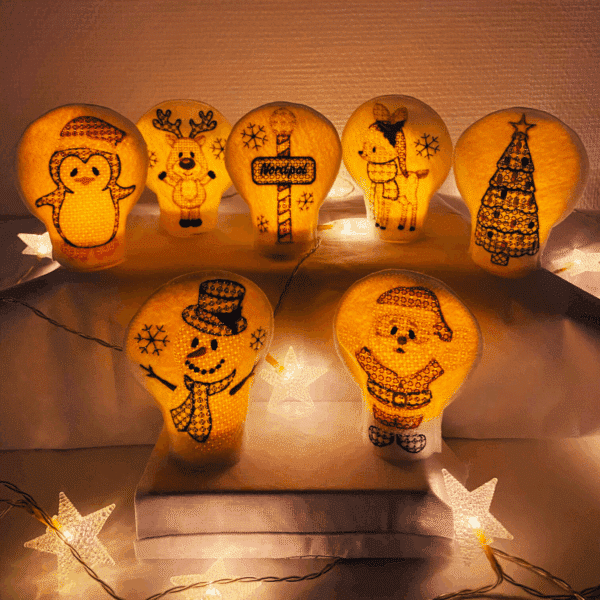 Teelichtcover mit Weihnachts-Motiven – beleuchtete Stickmotive wie Schneemann, Rentier, Weihnachtsbaum und Pinguin in festlicher Dekoration