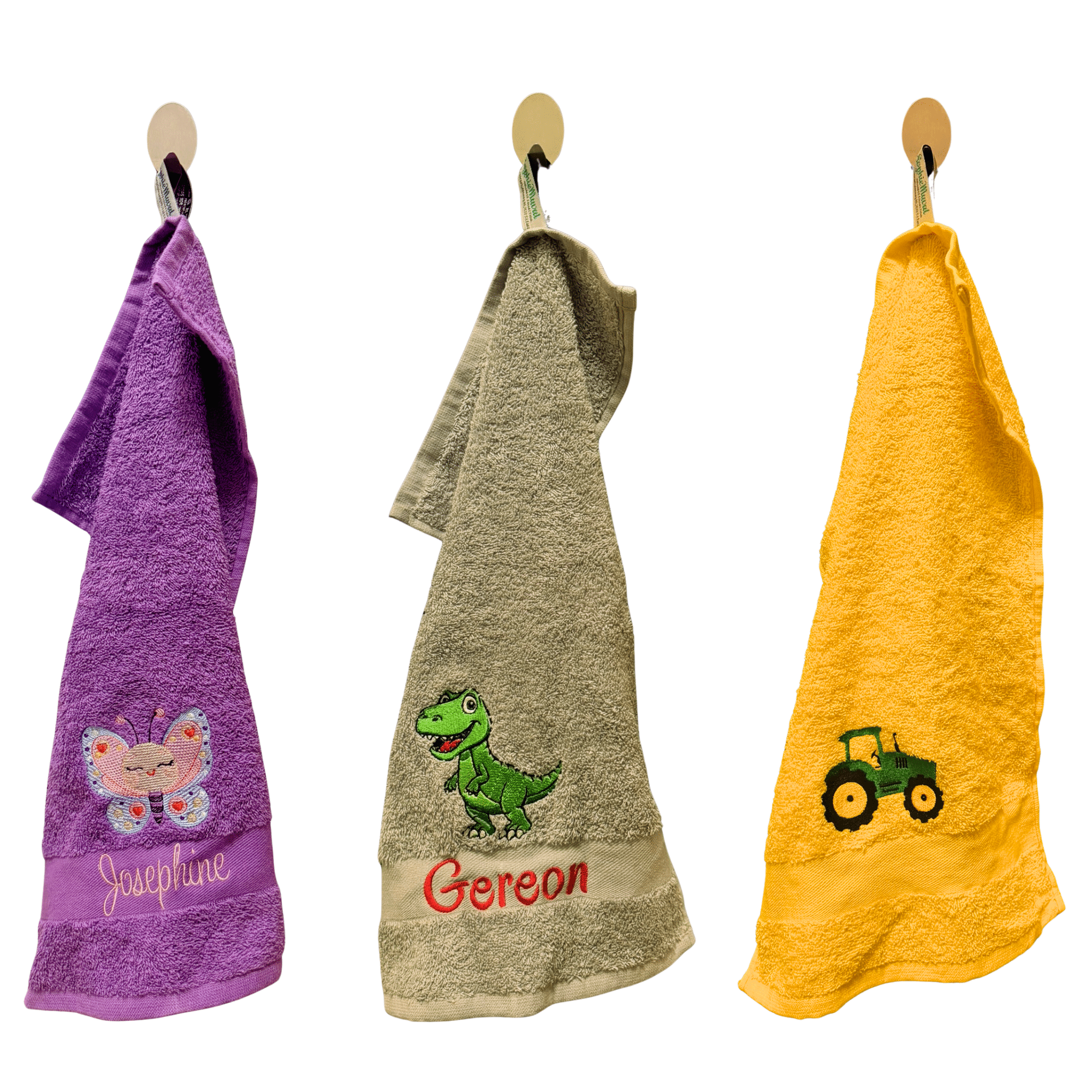 Drei personalisierte Kinderhandtücher mit Motiv und Name am Haken – Schmetterling, Dino und Traktor