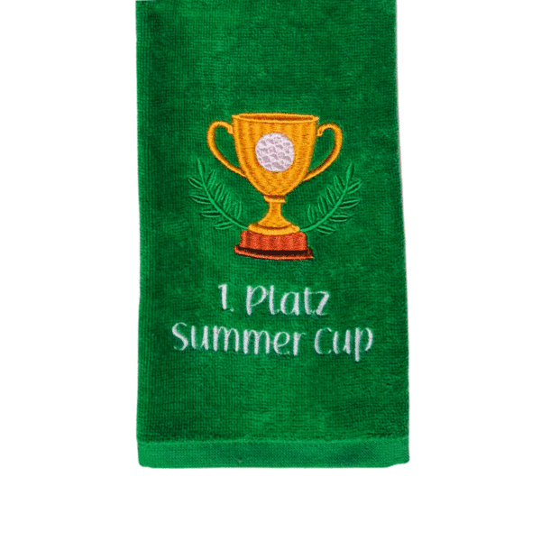 Detailansicht eines Golfhandtuchs mit goldenem Pokal, Golfball, Lorbeer und Wunschtext 1. Platz Summer Cup