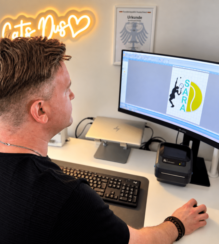 Moritz bearbeitet an einem Computer eine Stickdatei für ein personalisiertes Tennismotiv.